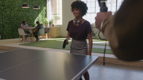 young-black-business-people-playing-ping-pong-in-office-enjoying-competitive-fun-colleague-using-smartphone-sharing-game-on-social-media-taking-video