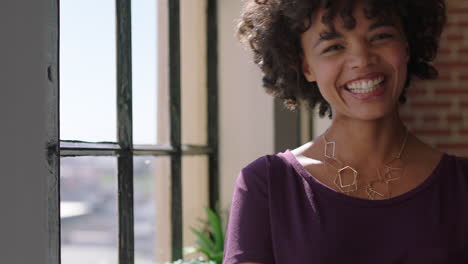 Porträt-Einer-Erfolgreichen-Afroamerikanischen-Frau,-Die-Aus-Dem-Fenster-Blickt-Und-In-Die-Kamera-Lächelt-Und-Einen-Positiven-Lebensstil-Genießt,-Der-Vorausschauend-Plant-Und-Sich-Zu-Hause-Entspannt.-Schwarze-Frau-Mit-Trendiger-Afro-Frisur