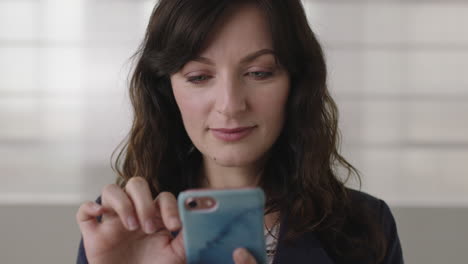 close-up-portrait-of-beautiful-young-business-woman-texting-browsing-using-smartphone-looking-at-camera-smiling-happy