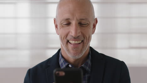 close-up-portrait-of-attractive-mature-businessman-smiling-texting-browsing-using-smartphone-networking-enjoying-online-mobile-communication