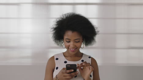 Retrato-De-Una-Hermosa-Joven-Afroamericana-Enviando-Mensajes-De-Texto-Navegando-Usando-Un-Teléfono-Inteligente-Disfrutando-De-La-Comunicación-Digital-Móvil