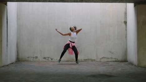 Mujer-Bailando-Joven-Bailarina-Callejera-De-Raza-Mixta-Realizando-Movimientos-De-Hip-Hop-Estilo-Libre-Disfrutando-De-La-Expresión-De-Danza-Moderna-Practicando-En-Un-Almacén-Sucio