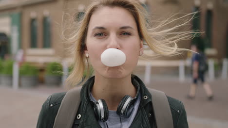 portrait-of-independent-blonde-woman-blowing-bubblegum-smiling-happy-cheerful-feeling-relaxed-carefree