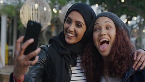 portrait-young-diverse-women-friends-using-smartphone-taking-selfie-photo-making-faces-enjoying-relaxed-fun-girlfriends-hang-out-in-city-slow-motion