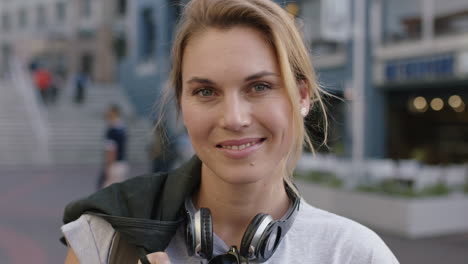 portrait-of-independent-blonde-woman-smiling-happy-optimistic-wearing-headphones-urban-city-sidewalk