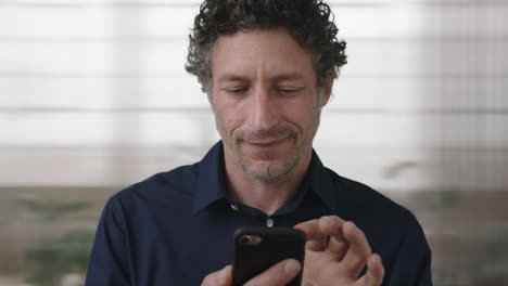 close-up-portrait-of-attractive-caucasian-man-texting-browsing-using-smartphone-enjoying-mobile-technology-in-office-background