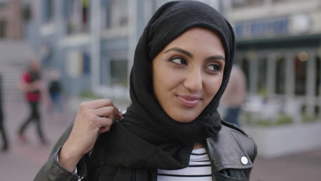 Porträt-Einer-Jungen-Schönen-Muslimischen-Frau,-Die-Lächelnd-Einen-Rucksack-Aufsetzt-Und-Lederjacke-Und-Hadschib-Trägt