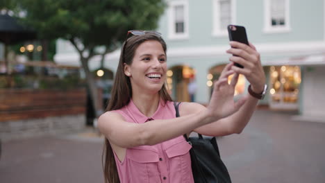 Retrato-En-Cámara-Lenta-De-Una-Joven-Hermosa-Mujer-Sonriendo-Posando-Tomando-Una-Foto-Selfie-Usando-Un-Fondo-Urbano-De-Teléfono-Inteligente