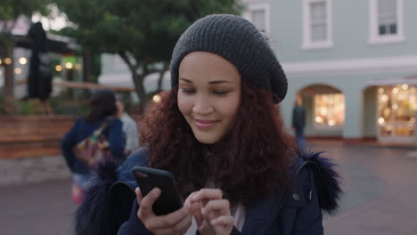 potrait-of-warmly-dressed-mixed-race-woman-looking-greeting-using-smartphone-texting-browsing-social-media