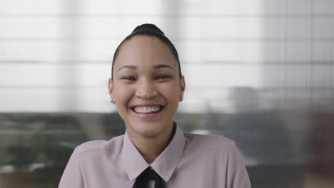 close-up-portrait-of-beautiful-young-mixed-race-business-woman-intern-laughing-cheerful-enjoying-fun-in-office-workspace-background