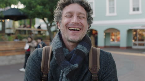 slow-motion-portrait-of-attractive-mature-caucasian-man-laughing-cheerful-at-camera-wearing-scarf-in-urban-background
