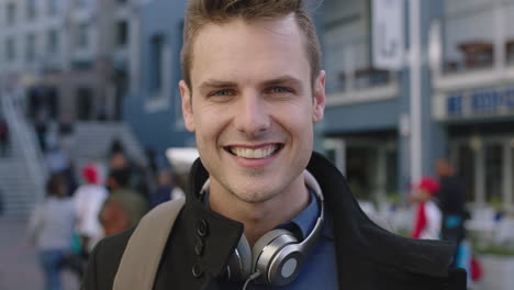 close-up-portrait-of-attractive-young-man-looking-at-camera-smiling-happy-in-busy-urban-background
