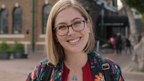 portrait-of-trendy-young-blonde-woman-smiling-confident-optimistic-running-hand-through-hair-wearing-glasses-floral-shirt