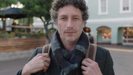 close-up-portrait-of-attractive-mature-caucasian-man-enjoying-travel-lifestyle-smiling-at-camera-in-urban-city-wearing-scarf