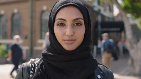 Porträt-Einer-Jungen-Schönen-Muslimischen-Frau,-Die-Ernst-Und-Selbstbewusst-In-Die-Kamera-Blickt-Und-Ein-Hadschib-Kopftuch-Trägt