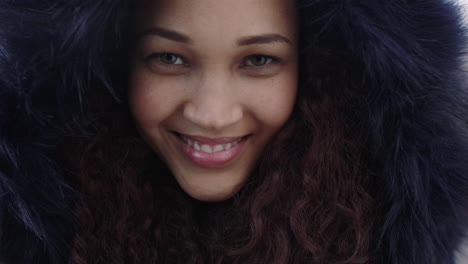 close-up-portrait-of-young-beautiful-mixed-race-woman-with-frizzy-hair-smiling-cheerful-wearing-fur-coat-looking-at-camera