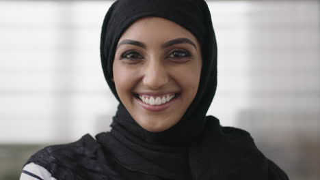 Porträt-Einer-Professionellen-Jungen-Muslimischen-Geschäftsfrau,-Die-Lachend-In-Die-Kamera-Blickt-Und-Ein-Traditionelles-Kopftuch-Im-Bürohintergrund-Trägt