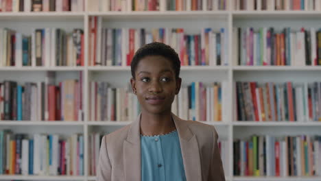 Porträt-Einer-Unabhängigen-Afroamerikanischen-Geschäftsfrau,-Die-Selbstbewusst-Aussieht-Und-Stilvolle-Mode-Im-Bücherregal-Hintergrund-Trägt