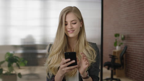 portrait-of-attractive-young-blonde-woman-executive-texting-browsing-using-smartphone-mobile-networking-app-in-modern-office-workspace
