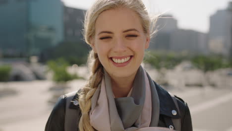 slow-motion-portrait-of-cute-young-blonde-woman-smiling-happy-cheerful-in-windy-city-enjoying-urban-lifestyle-wearing-scarf