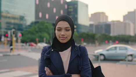 Retrato-De-Una-Joven-Mujer-De-Negocios-Musulmana-Ejecutiva-Mirando-Pensativa-A-La-Cámara-De-Pie-Con-Los-Brazos-Cruzados-En-La-Acera-Calle-Fondo-Urbano-De-La-Ciudad