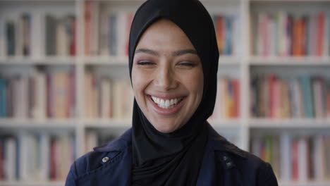 Porträt-Einer-Glücklichen-Jungen-Muslimischen-Frau,-Die-Fröhlich-Lächelt-Und-Eine-Erfolgreiche-Ausbildung-Genießt.-Unabhängige-Frau-Mit-Traditionellem-Hijab-Kopftuch-Im-Bücherregal-Hintergrund-In-Zeitlupe