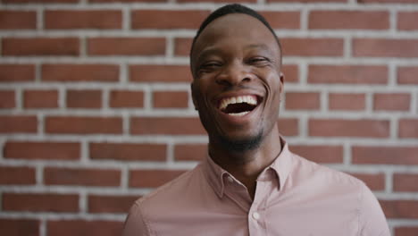 portrait-professional-young-african-american-businessman-laughing-enjoying-successful-lifestyle-confident-black-male-entrepreneur-on-brick-wall-background-slow-motion