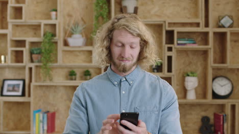 portrait-of-charming-geeky-hipster-man-texting-browsing-using-smartphone-smiling-feeling-connected