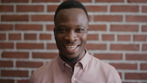 portrait-professional-young-african-american-businessman-smiling-enjoying-successful-lifestyle-confident-black-male-entrepreneur-on-brick-wall-background-slow-motion