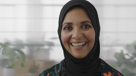 Nahaufnahme-Porträt-Einer-älteren-Muslimischen-Geschäftsfrau,-Die-Fröhlich-Lacht-Und-In-Die-Kamera-Blickt-Und-Ein-Traditionelles-Kopftuch-Trägt