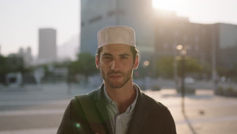 close-up-portrait-of-attractive-confident-middle-eastern-man-looking-serious-at-camera-pensive-in-urban-city-background-wearing-kufi-hat-sunset