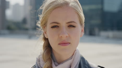 close-up-portrait-beautiful-blonde-woman-looking-serious-at-camera-in-city-wind-blowing-hair-pensive-caucasian-female-slow-motion