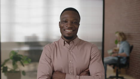 portrait-of-young-african-american-businessman-smiling-arms-crossed-enjoying-successful-start-up-business-confident-entrepreneur-in-modern-office-workspace