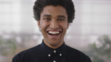 close-up-portrait-of-young-mixed-race-man-laughing-cheerful-looking-at-camera-enjoying-successful-job-opportunity-ambitious-male-in-office-workspace-background