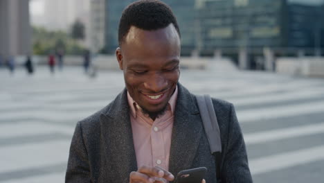 Porträt-Eines-Glücklichen-Afroamerikanischen-Geschäftsmannes,-Der-Sein-Smartphone-Nutzt-Und-Das-Surfen-Von-Online-Nachrichten-Beim-SMS-Schreiben-Auf-Dem-Mobiltelefon-In-Zeitlupe-In-Der-Stadt-Genießt