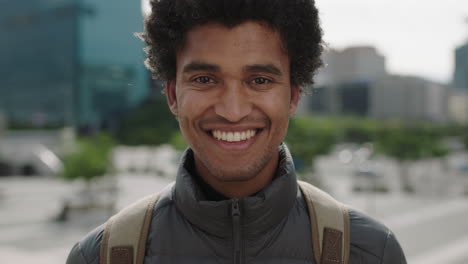 portrait-of-handsome-young-mixed-race-man-smiling-cheerful-at-camera-enjoying-sunny-urban-city-commuting-travel