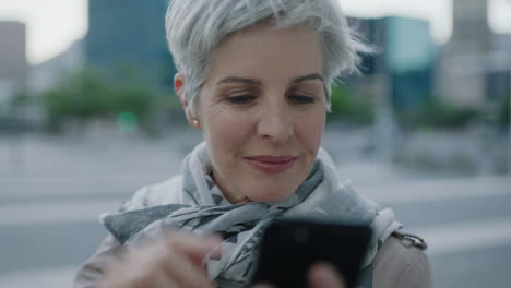 portrait-of-beautiful-mature-caucasian-woman-running-hand-through-hair-texting-browsing-using-smartphone-networking-app-enjoying-relaxed-urban-lifestyle
