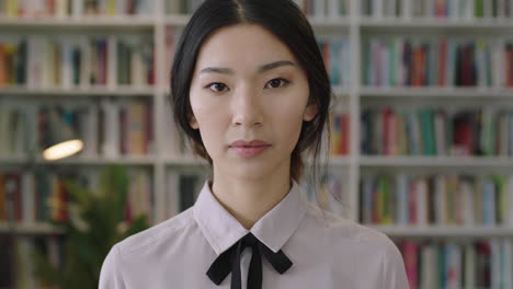 Nahaufnahme-Eines-Porträts-Einer-Schönen,-Süßen-Asiatischen-Studentin,-Die-Im-Bücherregal-Der-Bibliothek-Im-Hintergrund-Steht