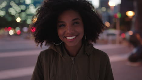 Porträt-Einer-Stilvollen-Jungen-Afroamerikanischen-Frau-Mit-Afro,-Die-Glücklich-In-Die-Kamera-Lächelt-Und-Das-Nachtleben-In-Der-Stadt-Genießt
