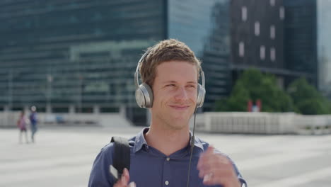 portrait-attractive-young-man-smiling-listening-to-music-takes-off-headphones-in-city-enjoying-relaxed-urban-lifestyle-on-sunny-day-slow-motion-leisure-entertainment