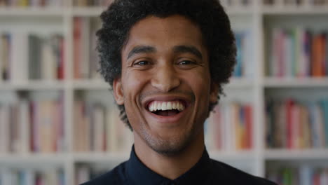 portrait-young-happy-mixed-race-man-student-laughing-enjoying-successful-education-lifestyle-independent-male-in-library-background-slow-motion