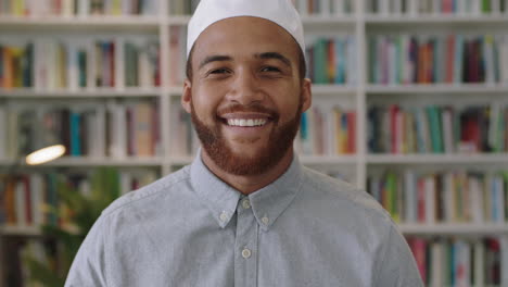 Un-Joven-Confiado-Del-Medio-Oriente-Parado-En-La-Biblioteca-Mirando-Un-Retrato-Sonriente-De-Un-Orgulloso-Empresario