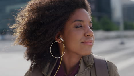 Nahaufnahme-Eines-Porträts-Einer-Schönen-Jungen-Afroamerikanischen-Frau,-Die-Kopfhörer-Aufsetzt-Und-In-Der-Stadt-Musik-Hört-Und-Einen-Entspannten-Urbanen-Lebensstil-In-Zeitlupe-Genießt