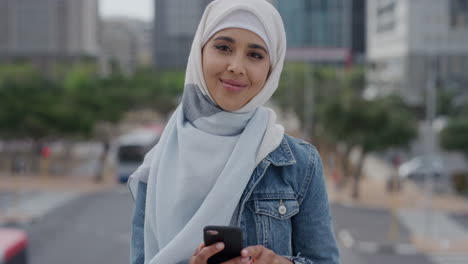 Retrato-De-Una-Joven-Musulmana-Usando-Un-Teléfono-Inteligente-En-La-Ciudad-Disfrutando-De-Mensajes-De-Texto-Navegando-Por-Mensajes-En-Un-Teléfono-Móvil-Usando-Un-Velo-Hijab-Comunicación-Por-Teléfono-Celular