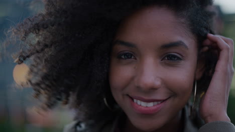 close-up-portrait-beautiful-young-african-american-woman-smiling-running-hand-through-hair-independent-black-female-enjoying-lifestyle-in-city-wind-blowing-afro-hairstyle