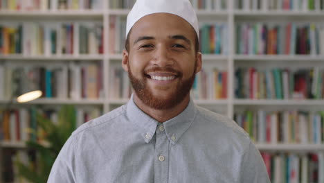 Un-Joven-Confiado-Del-Medio-Oriente-Parado-En-La-Biblioteca-Mirando-Un-Retrato-Sonriente-De-Un-Orgulloso-Empresario