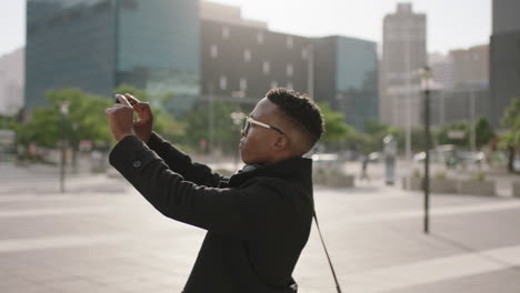 Porträt-Eines-Trendigen-Afroamerikanischen-Studenten,-Der-Mit-Smartphone-Videotechnologie-Fotos-Von-Der-Stadt-Macht-Und-Dabei-Sightseeing-Reisen-Genießt