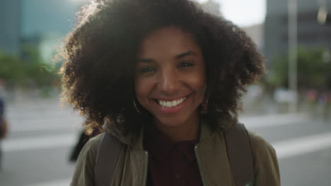 Porträt-Einer-Schönen,-Trendigen-Afroamerikanischen-Frau,-Die-In-Die-Kamera-Lächelt-Und-Selbstbewusst-Aussieht,-Während-Sie-Mit-Der-Hand-Durchs-Haar-Läuft-Und-Den-Urbanen-Stadtlebensstil-Genießt