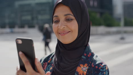 Primer-Plano-Retrato-De-Una-Mujer-Musulmana-De-Alto-Rango-Usando-Un-Teléfono-Inteligente-En-La-Ciudad-Disfrutando-Leyendo-Mensajes-En-Línea-Enviando-Mensajes-De-Texto-En-Un-Teléfono-Móvil-Estilo-De-Vida-Urbano-Moderno