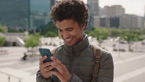 portrait-of-handsome-young-mixed-race-man-enjoying-browsing-texting-using-smartphone-social-media-app-in-sunny-urban-city-background
